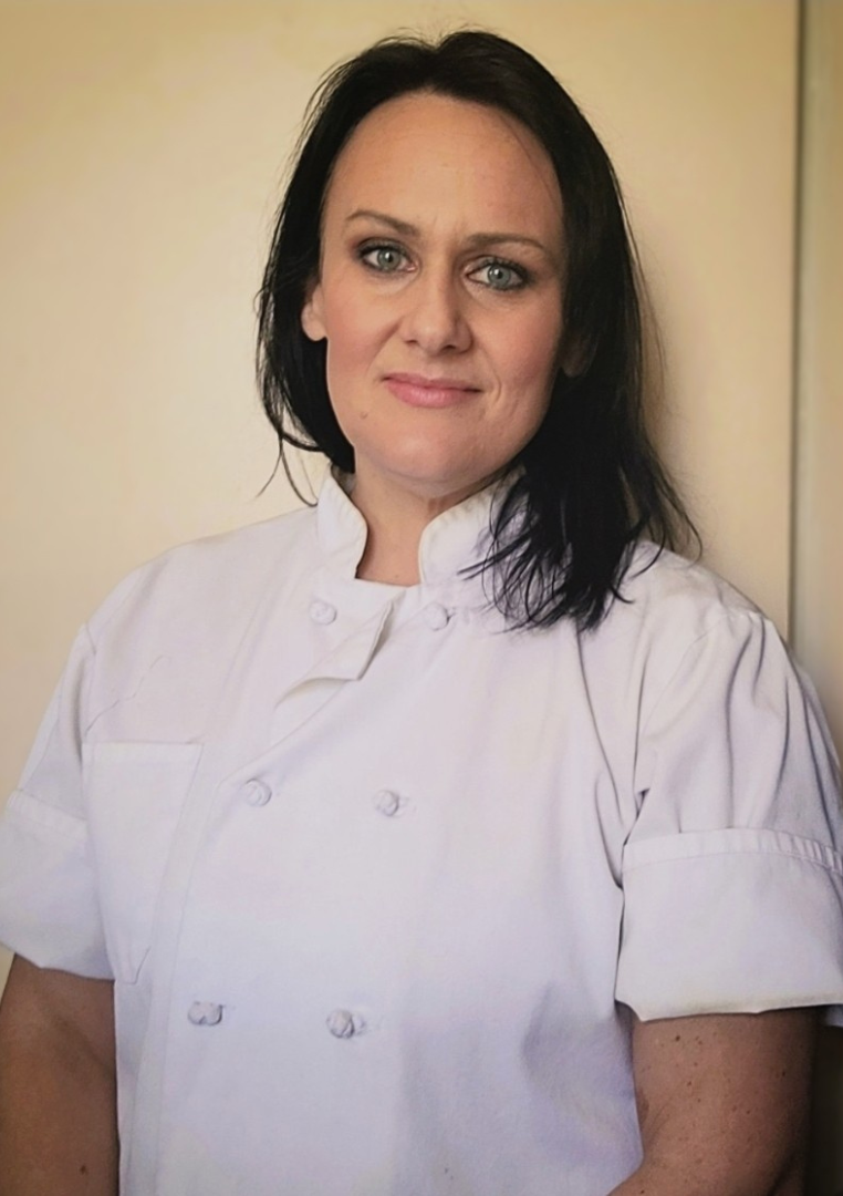 Chef Sydney smiling headshot in white apron